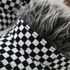 Detail of black and white checkered baseball cap with fluffy grey synthetic hair wig