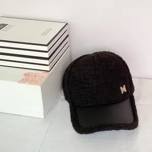 Close-up of black fleece baseball cap with leather brim and gold M letter detail