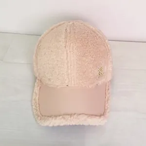 Detailed view of pink fleece baseball cap with gold M logo and leather brim accent