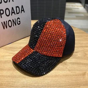Detail der schimmernden Strasssteine auf der schwarz-orangen zweifarbigen Baseballkappe