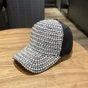 Detailed view of black baseball cap with luxury white pearls and sparkling rhinestones