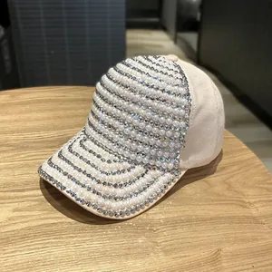 Close-up of elegant beige baseball cap with luxury pearl and rhinestone embellishments