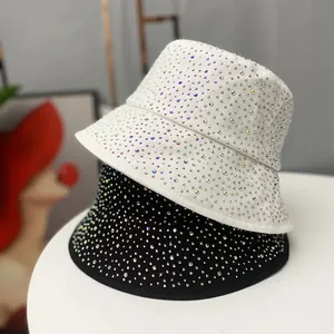 Détail des strass multicolores scintillants sur les bobs en coton noir et blanc