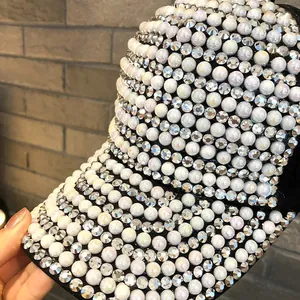 Detailed view of the black baseball cap featuring dense white pearl and rhinestone embellishments