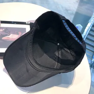 Inside view of a black baseball cap showing the sweatband and adjustable plastic snap closure