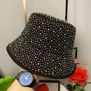 Détail de strass colorés sur un chapeau bob en coton noir avec des bords larges