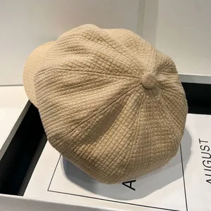 Detailopname van een kaki bakkerspet van wafelstof in een witte geschenkverpakking