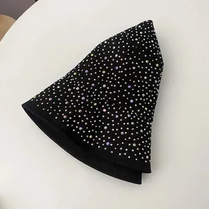 Gros plan de strass colorés étincelants sur un chapeau bob en coton noir, vue à plat