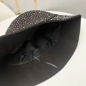 Détail de la broderie en strass et du cordon de serrage réglable à l'intérieur du chapeau