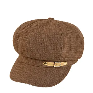 Bruine newsboy pet in Britse stijl met wafeltextuur en lederen riemdetail op de klep