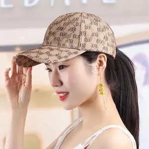 Detail of light brown baseball cap featuring all-over BF print and rhinestone accents