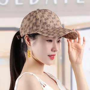 Detailed close-up of khaki baseball cap with BF monogram pattern and shiny rhinestones