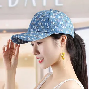 Close-up of light blue denim baseball cap with rhinestone BF lettering on model