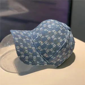 Detail of light blue denim baseball cap with BF letter print and rhinestone stars
