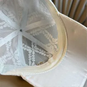 Detailed interior view of beige lace baseball cap showing breathable mesh lining