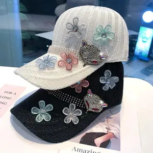 Dettaglio del distintivo volpe in strass e fiori in tulle su cappellino in maglia di lusso