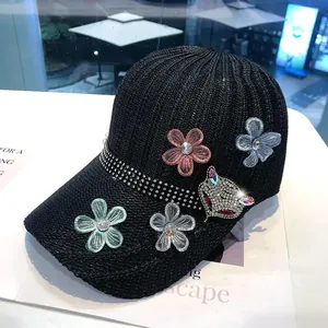 Dettaglio del cappello nero in maglia con strass, motivo a volpe e fiori di organza