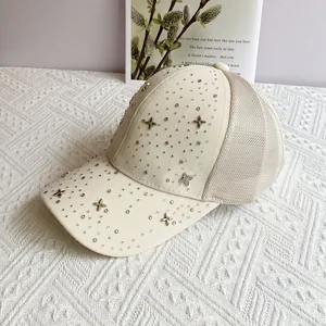 Detail of off-white mesh baseball cap with sparkling rhinestones and metal clover studs