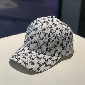Detail of white baseball cap featuring black BF monogram print and shimmering rhinestones