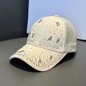 Detailed view of beige baseball cap featuring rhinestone letters and breathable mesh back