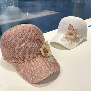 Detailed knit of pink and white baseball caps with 3D fabric flowers and mesh