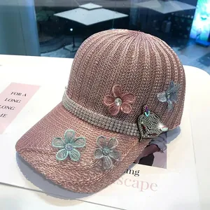 Dettaglio del berretto in maglia rosa con toppa a volpe in strass e decorazioni floreali