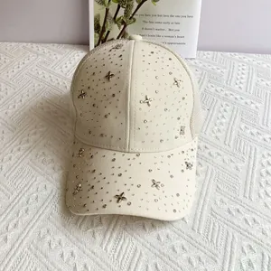 Detailed close-up of beige mesh baseball cap with rhinestones and silver star studs