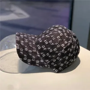 Detail of black baseball cap with white BF monogram print on a spherical mold