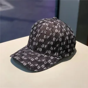 Detail shot of the rhinestone grid and white BF letter print on the grey baseball cap