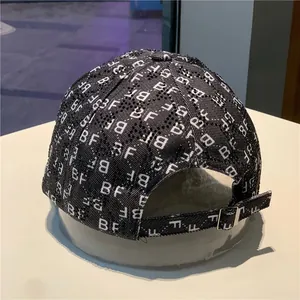 Close-up of black baseball cap featuring BF monogram print and shiny rhinestone details