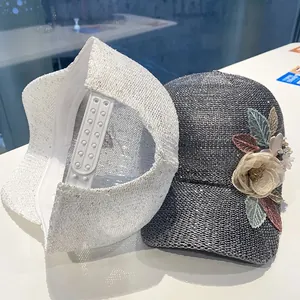 Detail of sequins on white baseball cap and fabric flower on grey knitted sun hat