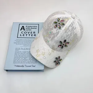 Elegante cappello baseball da donna in pizzo bianco con decorazioni di fiori in strass