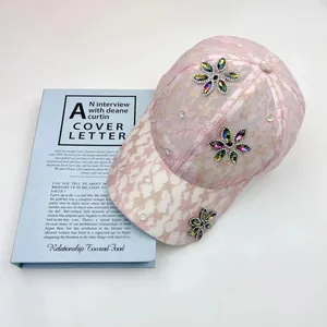 Dettaglio del cappellino in pizzo rosa con eleganti fiori di strass dai riflessi cangianti