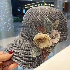 Close-up of grey knitted baseball cap with 3D fabric flowers and sequined leaf embroidery
