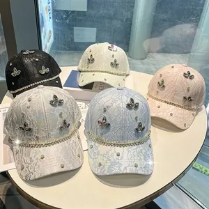 Dettaglio di cappellini in pizzo con quadrifoglio di strass e catene lucide in cinque colori