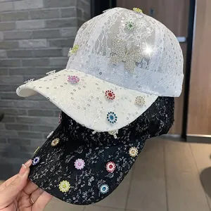 Detail von Spitzen-Baseballkappen mit bunten Strass-Schmetterlingen und Pailletten