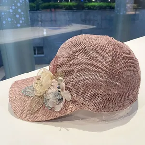 Detail of pink knitted baseball cap with sequins and delicate handmade fabric flowers