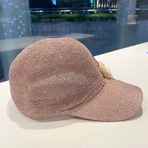 Close-up of pink knit baseball cap with sequins and a side lace flower detail