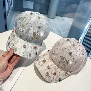 Detailansicht von Spitzen-Baseballkappen mit glitzernden Strass-Schmetterlingen in Grau