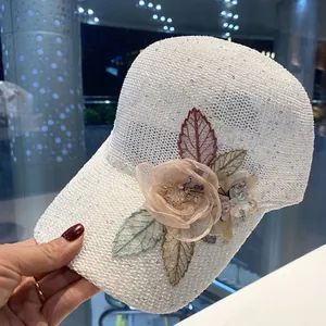 Detailed shot of white knitted baseball cap featuring mesh flowers and shiny sequins
