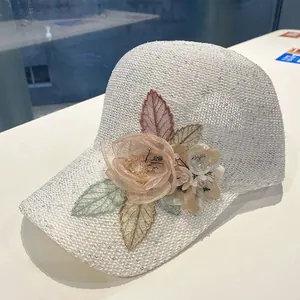 Close-up of white knitted baseball cap featuring 3D lace flowers and sequins