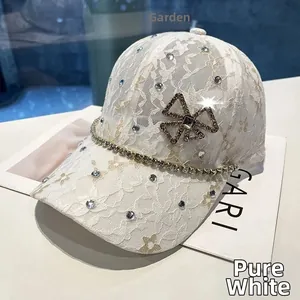 Close-up of white lace baseball cap featuring sparkling rhinestones and a delicate bow detail