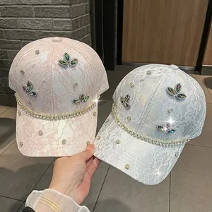 Dettagli di eleganti cappellini in pizzo con trifogli di strass e catene scintillanti
