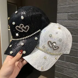 Detail of lace baseball cap with rhinestone double heart patterns and decorative chains