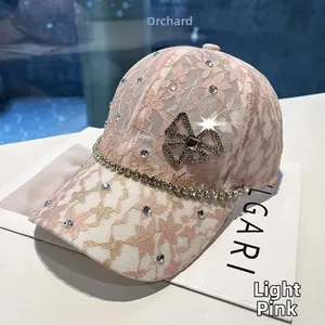 Detailed view of light pink lace baseball cap with sparkling rhinestones and gold buckle