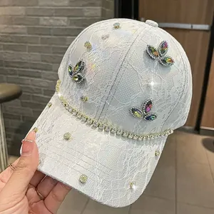 Dettaglio cappello baseball in pizzo bianco con farfalle di pietre preziose e strass