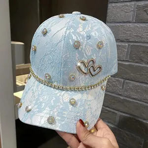 Detail of light blue lace baseball cap with sparkling rhinestones and double heart buckle
