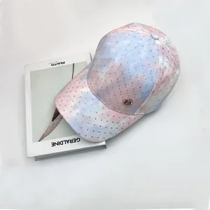 Detailed close-up of pink tie-dye baseball cap with sparkling rhinestones and metal logo