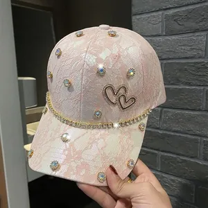 Detail of pink lace baseball cap with rhinestone heart patch and crystal chain trim