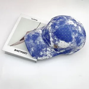 Blue and white tie-dye baseball cap with sparkling rhinestones and golden emblem
